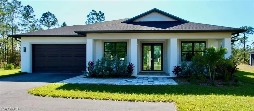 View of front of house featuring a front yard and a garage