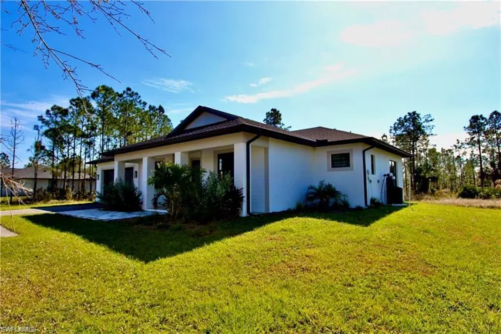 View of property exterior featuring a lawn