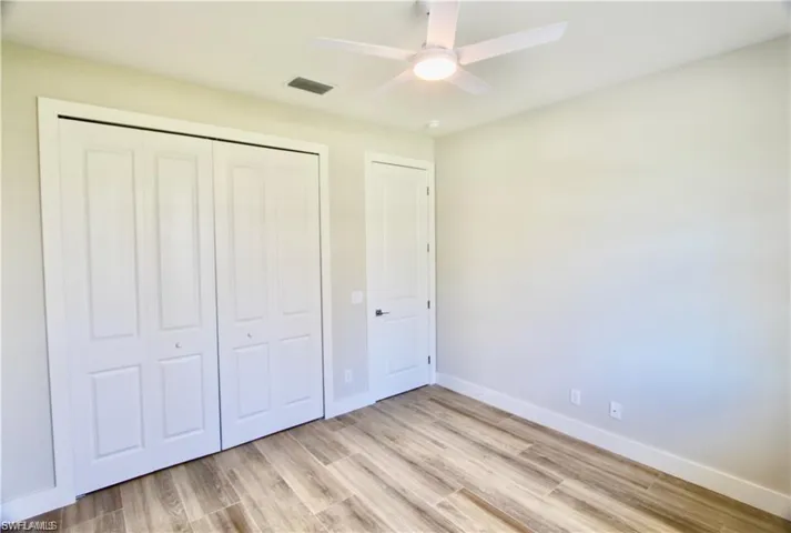 Unfurnished bedroom featuring ceiling fan, a closet, and light hardwood / wood-style flooring