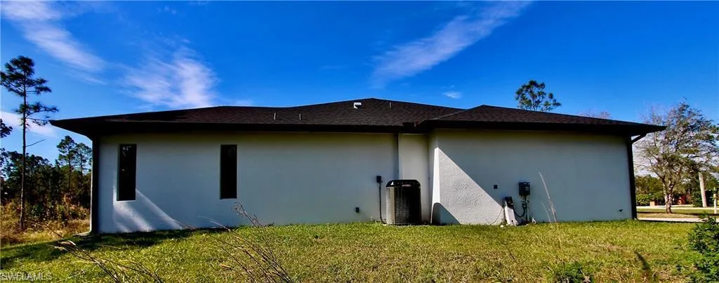View of side of property featuring a lawn