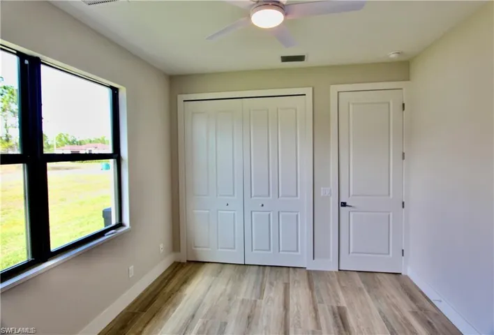 Unfurnished bedroom featuring ceiling fan, a closet, and light hardwood / wood-style floors