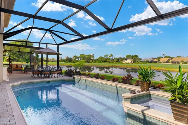 View of swimming pool featuring a lanai, a water view, and a patio