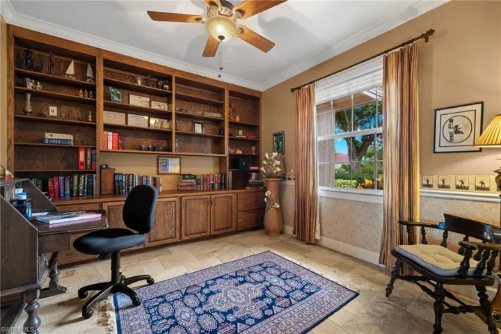 Office with crown molding and ceiling fan