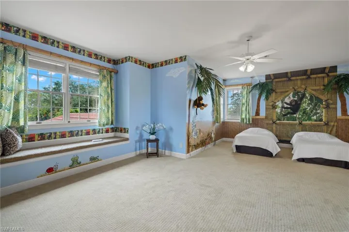 Bedroom with carpet, ceiling fan, and multiple windows