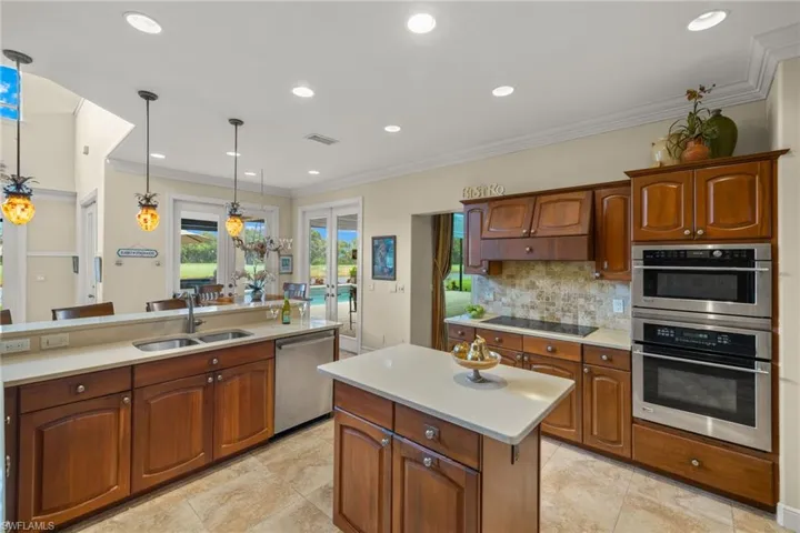 Kitchen featuring appliances with stainless steel finishes, a center island, sink, and hanging light fixtures