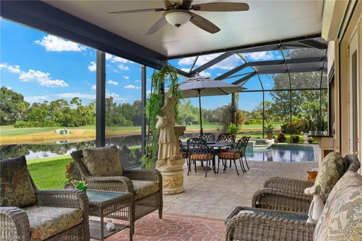 Sunroom / solarium with a water view and ceiling fan