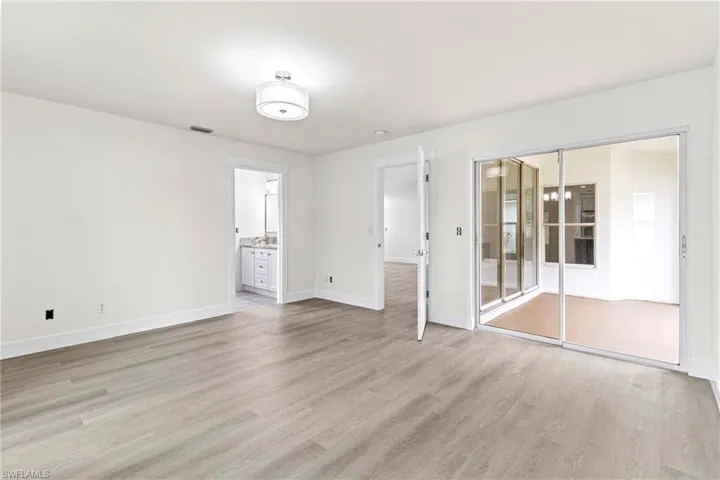 Unfurnished bedroom featuring a closet, hardwood / wood-style floors, and connected bathroom