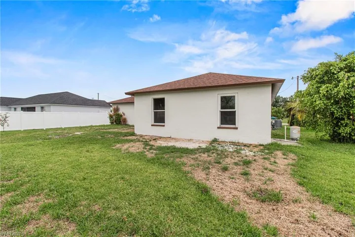 Rear view of property with a yard