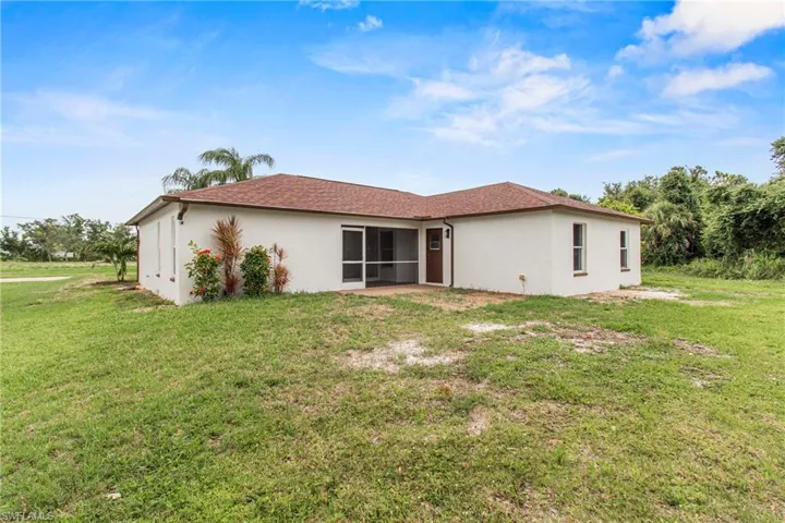 Back of property featuring a yard