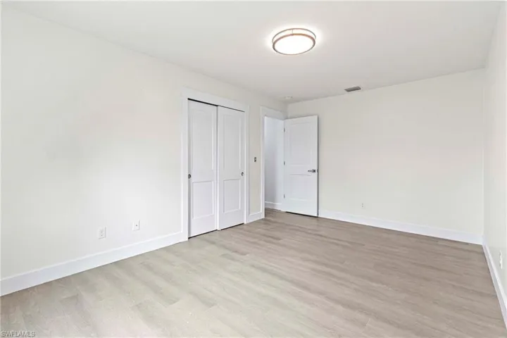Unfurnished bedroom featuring a closet and light wood-type flooring