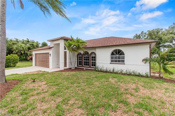 Mediterranean / spanish house featuring a front lawn and a garage