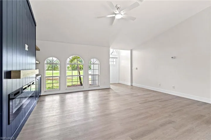 Unfurnished living room featuring high vaulted ceiling, ceiling fan, and light hardwood / wood-style flooring