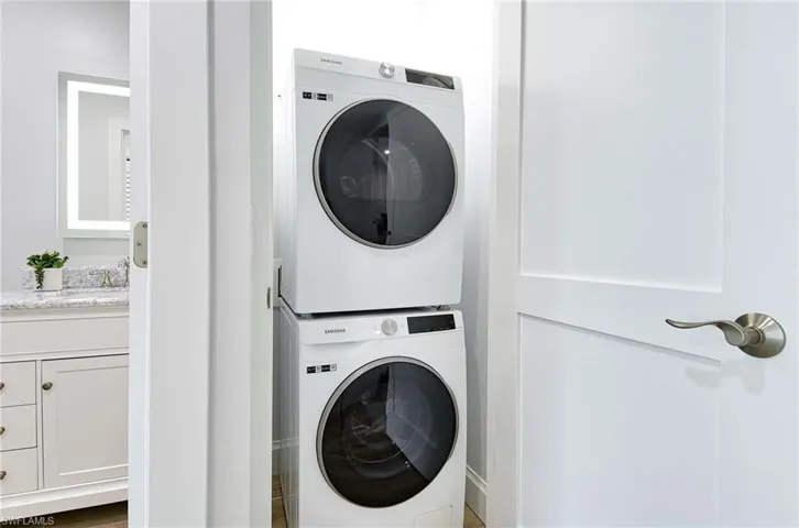 Washroom featuring stacked washer / dryer