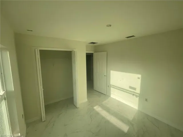 Unfurnished bedroom with a closet and light tile patterned floors