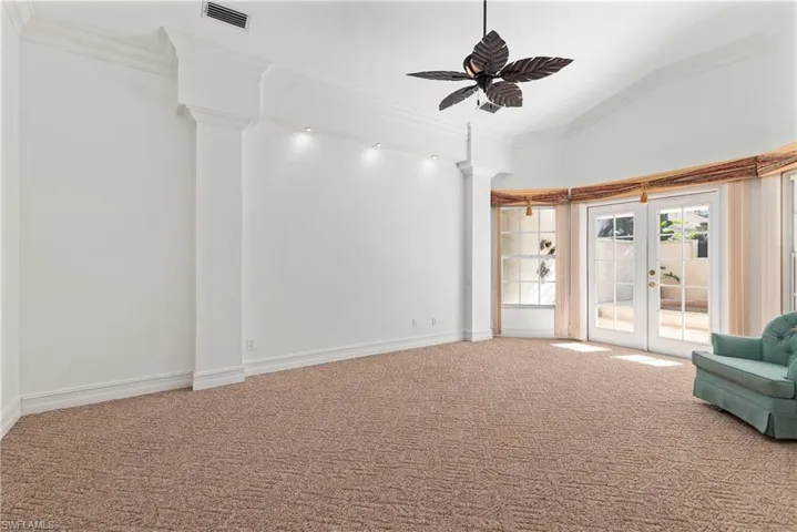 Large owner's suite with sitting area and French doors that lead out to the private spa and pool.