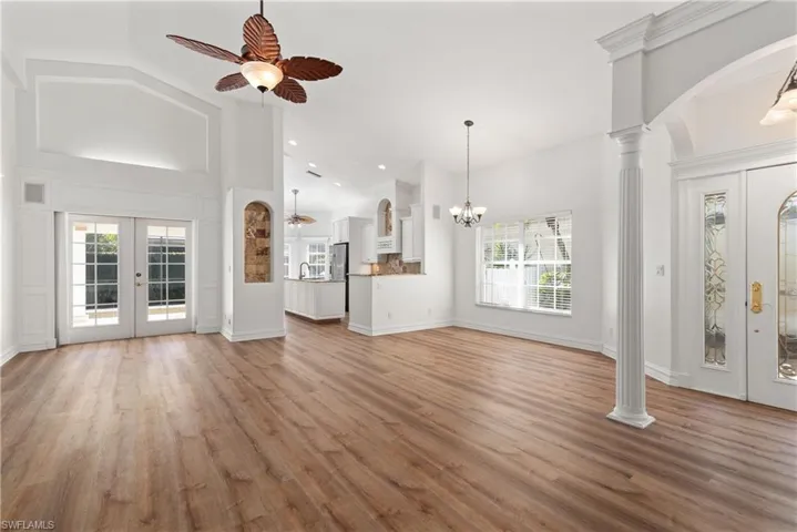 View of front door, French doors leading out to screened lanai and pool area, formal dining area and kitchen.