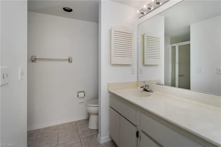 Full bathroom with a shower stall, vanity, and light tile patterned floors
