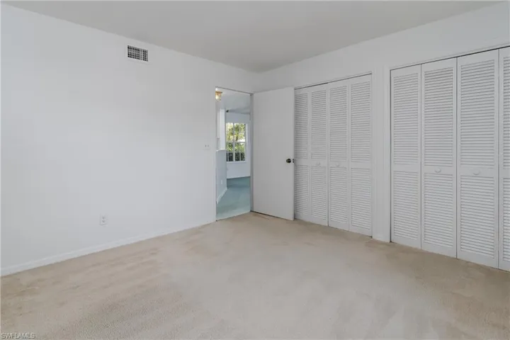 Unfurnished bedroom featuring carpet floors and multiple closets