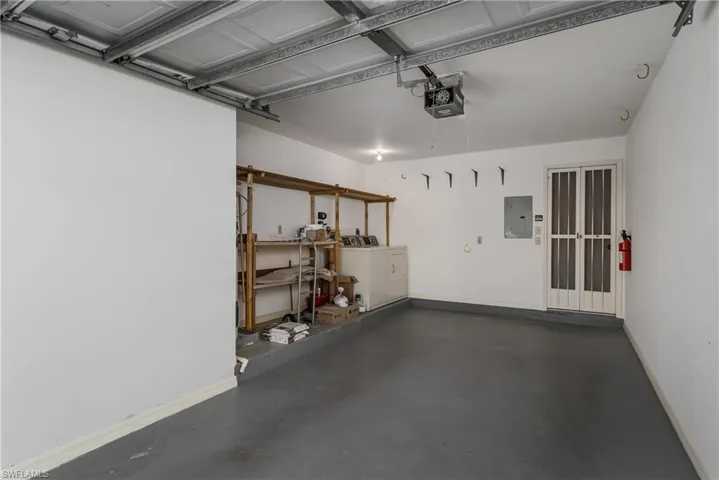 Garage with electric panel, washer and dryer, and a garage door opener