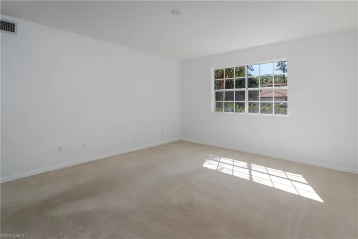 Empty room featuring baseboards and light carpet