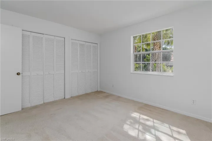 Unfurnished bedroom with multiple closets and light colored carpet