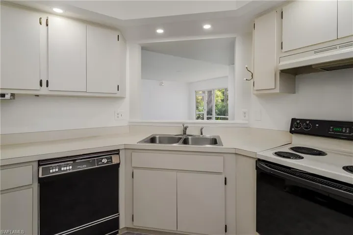 Kitchen featuring range with electric stovetop, black dishwasher, light countertops, recessed lighting, and white cabinetry