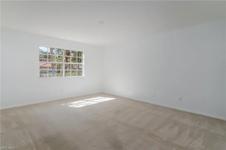 Unfurnished room with baseboards and light carpet