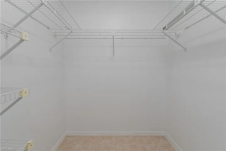 Walk in closet with light tile patterned floors