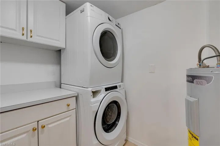The laundry room features a new water heater with a code-compliant drip pan, access to HVAC, a new electric panel, new whole home surge protector and a convenient storage and folding area.