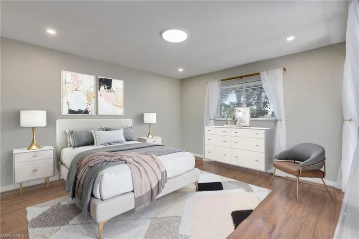 Virtually staged: primary bedroom suite with new flush mount LED ceiling lighting and direct access to the large lanai. Ample space for king size bed.