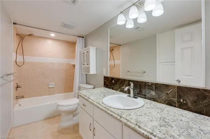 The guest bathroom features, new faucet, new shower, LED flush mount light and tons of storage underneath the vanity and Built into the wall opposite the vanity