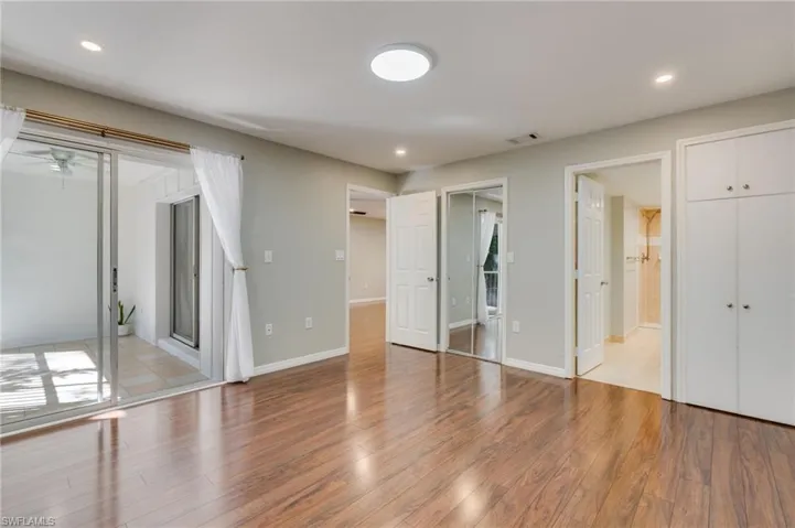 The large primary bedroom has direct access to the lanai in tons of storage space in addition to the walk-in closet with custom shelving.