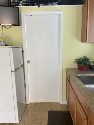 Kitchen with freestanding refrigerator and wood finish cabinets