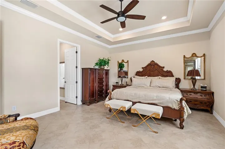 Bedroom featuring a raised ceiling, visible vents, and baseboards