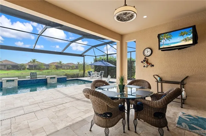View of patio with glass enclosure, outdoor dining space, an outdoor pool, and a hot tub