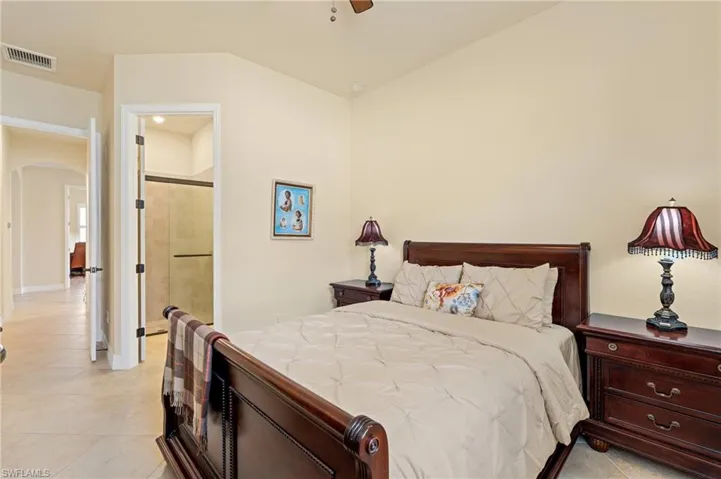 Bedroom featuring arched walkways, visible vents, and light tile patterned floors