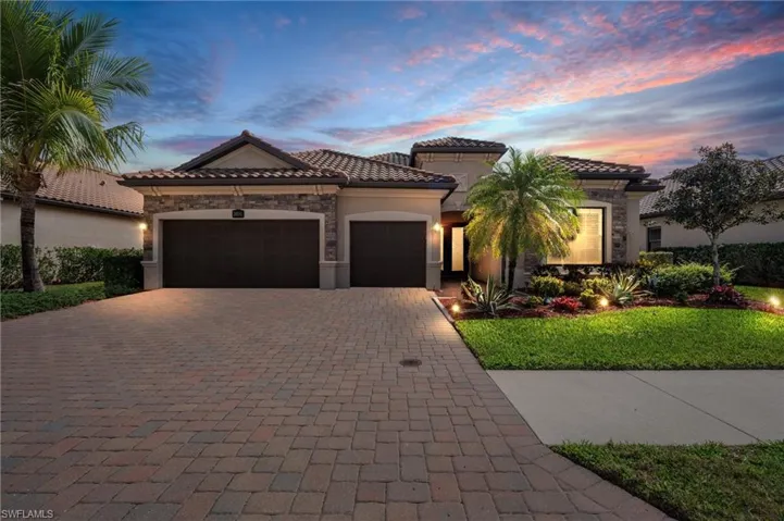 Mediterranean / spanish home featuring a garage, a tile roof, stone siding, decorative driveway, and stucco siding