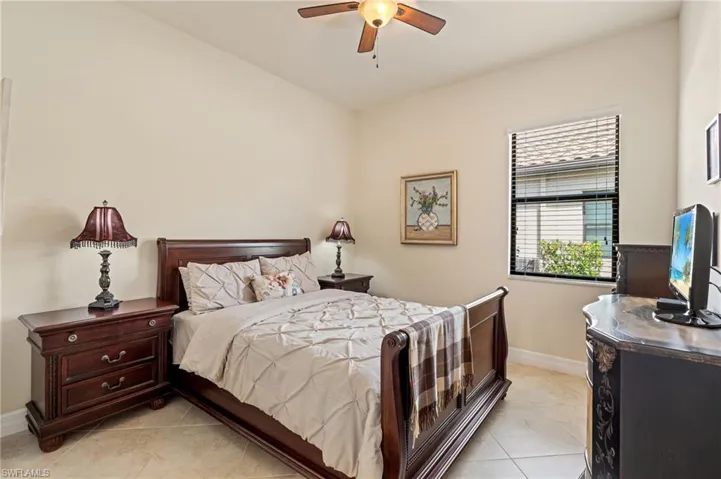 Bedroom featuring a ceiling fan, light tile patterned flooring, and baseboards