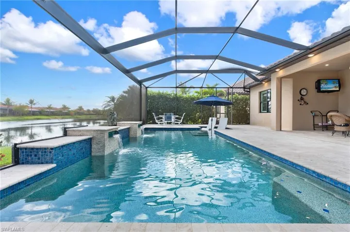 Outdoor pool featuring a patio area, a water view, and a lanai