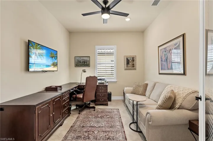 Office space with visible vents, ceiling fan, baseboards, and light tile patterned floors