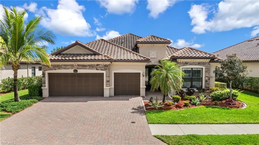 Mediterranean / spanish home featuring a garage, stone siding, a tiled roof, decorative driveway, and stucco siding