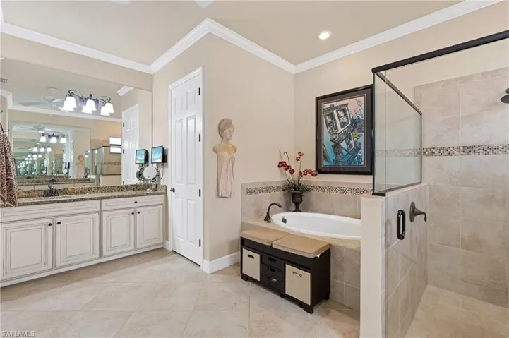 Bathroom with a stall shower, tile patterned flooring, crown molding, vanity, and a bath