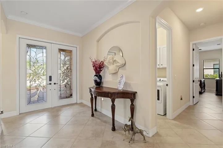 Foyer featuring washer / clothes dryer, baseboards, french doors, and light tile patterned floors