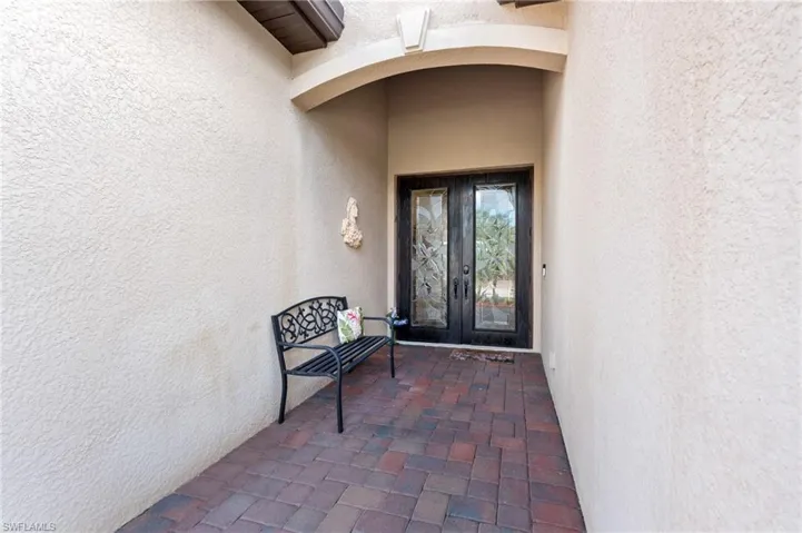 View of exterior entry featuring french doors and stucco siding