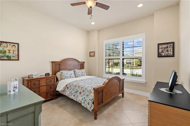 Bedroom with light tile patterned floors, ceiling fan, baseboards, and recessed lighting