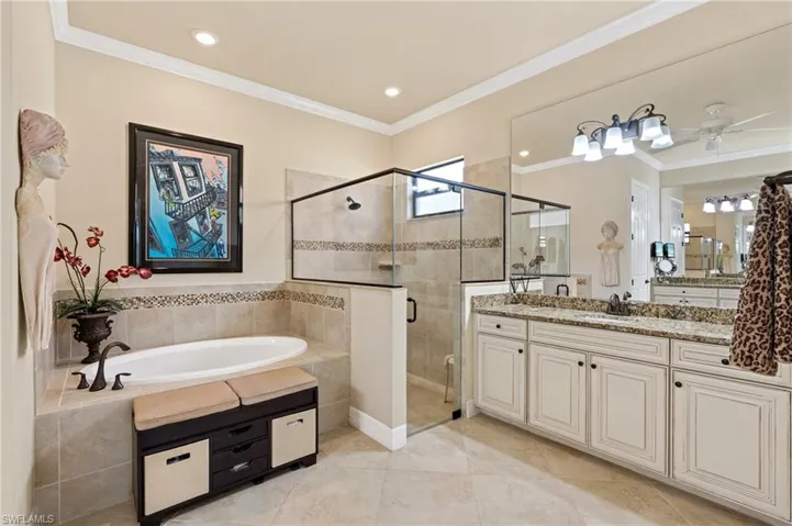 Bathroom featuring a stall shower, vanity, a bath, and crown molding