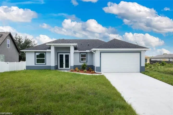 View of front of house featuring a front yard and a garage