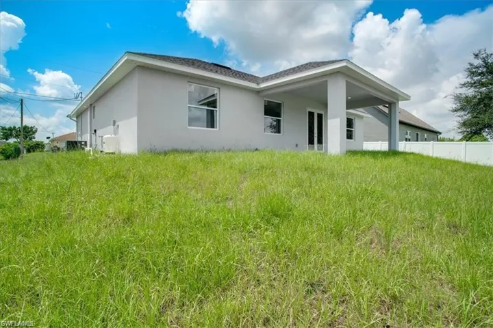 Rear view of house featuring a lawn