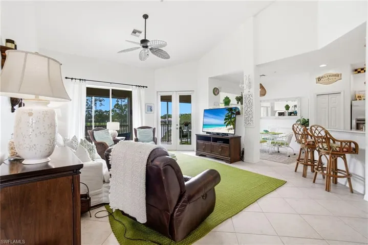 Expansive floor plan with 3 bedrooms, 2 bathrooms, soaring high ceilings, stylish beach-inspired furnishings, and elegant rattan light fixtures throughout.
