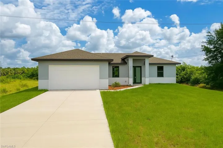 View of front of home featuring stucco siding, a front lawn, driveway, an attached garage, and roof with shingles